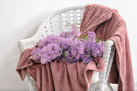 Beautiful lilac flowers on wicker armchairの写真素材