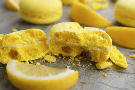 Crushed fresh macaron and lemon slice on wooden table, closeupの写真素材