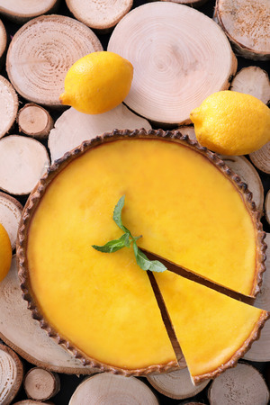 Delicious lemon pie on wood logs backgroundの写真素材