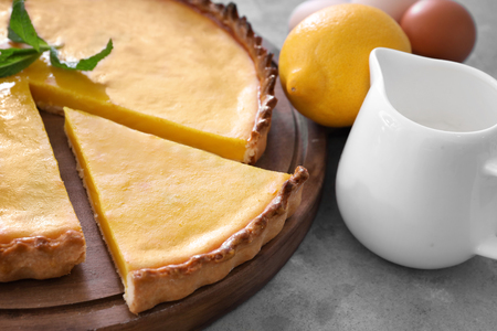 Wooden board with delicious lemon pie on gray table, closeupの写真素材