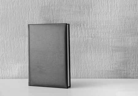Book with blank black cover on tableの写真素材