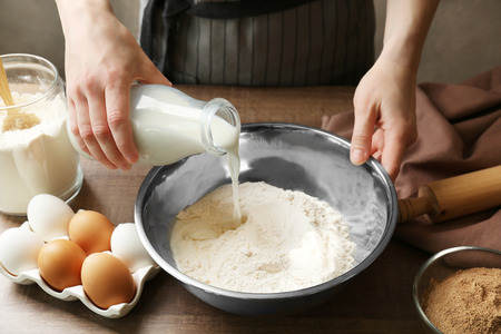 Woman making dough for cinnamon rolls in kitchenの写真素材