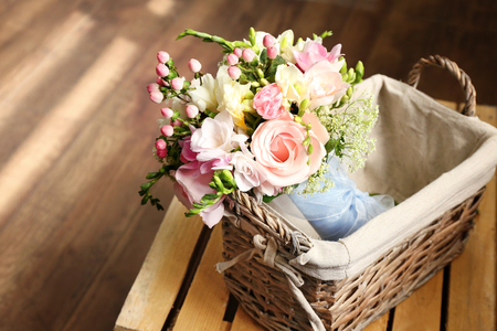 Beautiful bouquet with freesia flowers in basket on wooden crateの写真素材