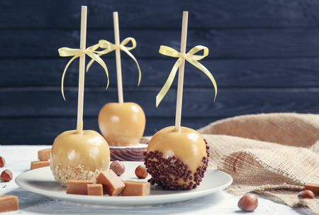 Plate with delicious candy apples on tableの写真素材