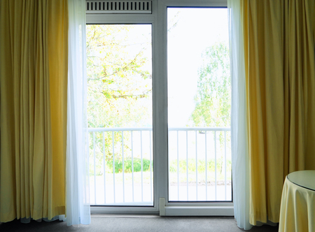Big window with yellow curtains in apartmentの写真素材