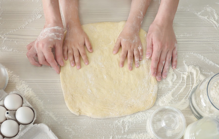 Family preparing dough together in kitchen. Cooking classes concept