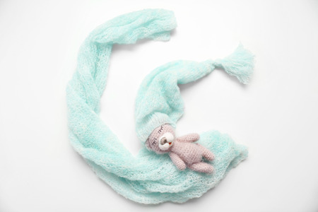 Adorable knitted toy with baby clothes in shape of moon isolated on whiteの写真素材