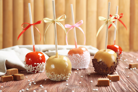 Delicious candy apples on wooden tableの写真素材