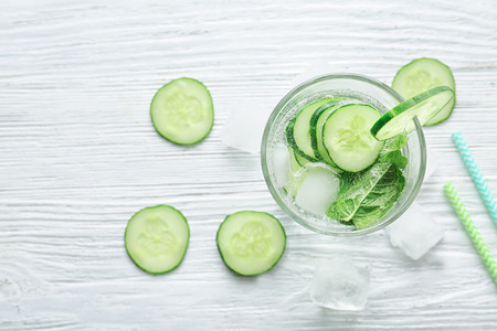 Glass of fresh cucumber lemonade on wooden backgroundの写真素材