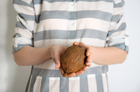 Young woman with coconut on white background