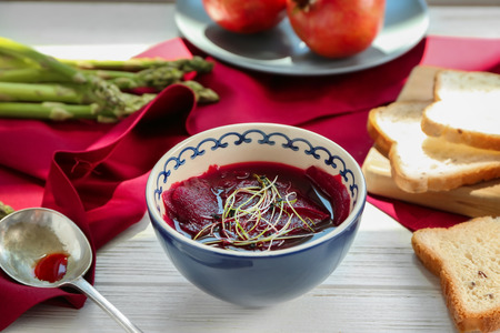 Delicious beet soup with wheat germs in bowl on kitchen table