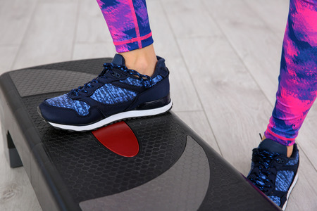 Young sporty woman training legs with stepper in gymの写真素材