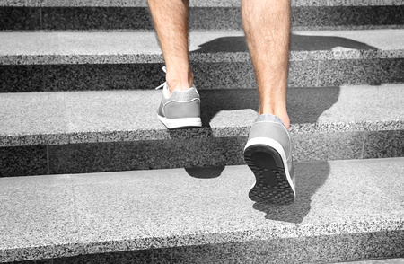 Sporty man running up stone stairsの写真素材