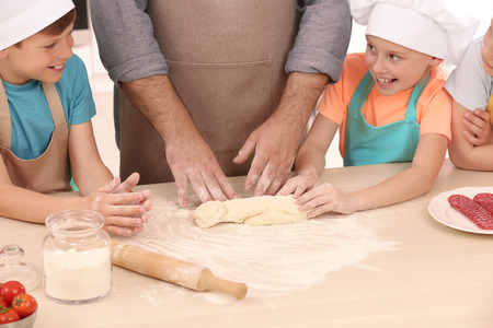 Group of children and teacher in kitchen during cooking classesの写真素材