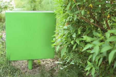Empty sign board on lawn in parkの写真素材