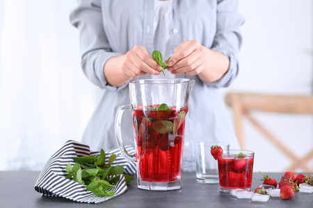 Woman preparing lemonade in kitchenの写真素材
