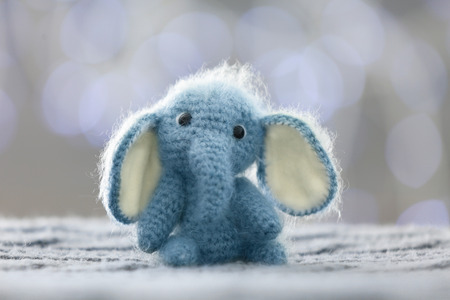 Knitted toy elephant on blurred background