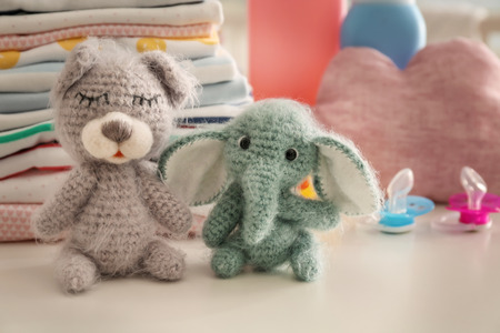 Cute knitted toys and baby clothes on tableの写真素材