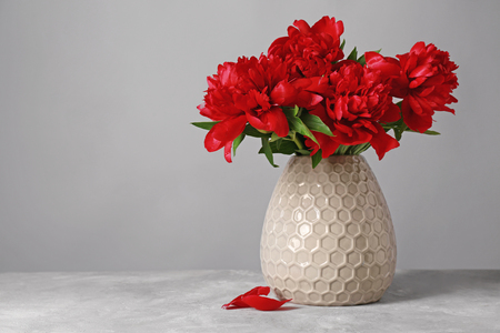 Vase with beautiful peonies on stone tableの写真素材