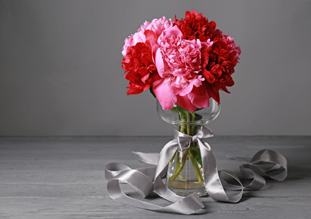 Vase with beautiful peonies on wooden tableの写真素材