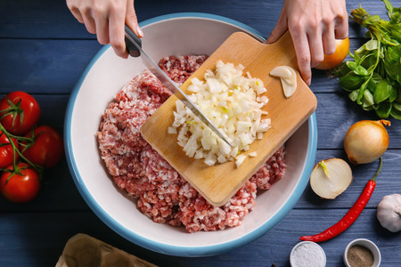 Woman preparing delicious turkey meatloaf in bowlの写真素材