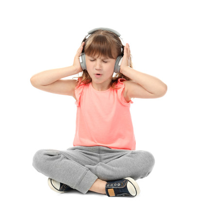 Cute funny girl with headphones listening to music on white backgroundの写真素材