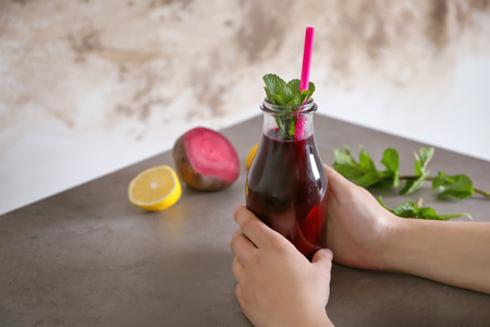 Young woman holding glass of beet smoothieの写真素材