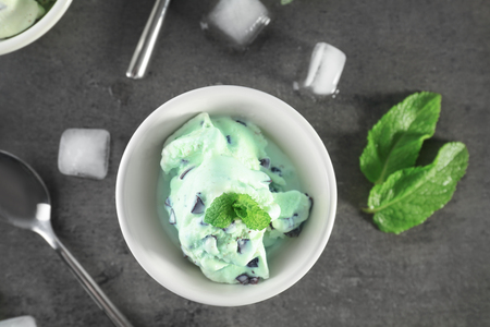 Bowl with delicious mint chocolate chip ice cream on grey tableの写真素材