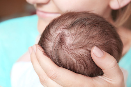 Happy young woman holding her newborn baby boy, closeupの写真素材