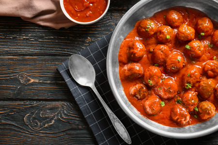 Saucepan with delicious meatballs in tomato sauce on tableの写真素材