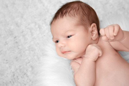 Newborn baby boy lying on soft plaid at homeの写真素材