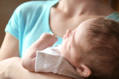 Happy young woman holding her newborn baby boy, closeupの写真素材