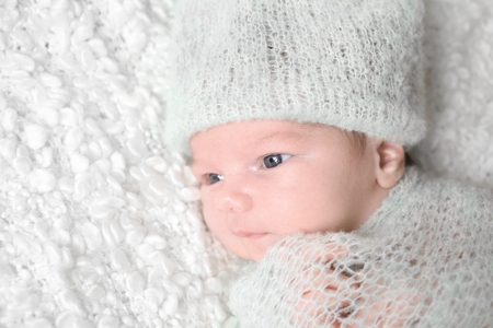 Newborn baby boy lying on soft plaid at homeの写真素材