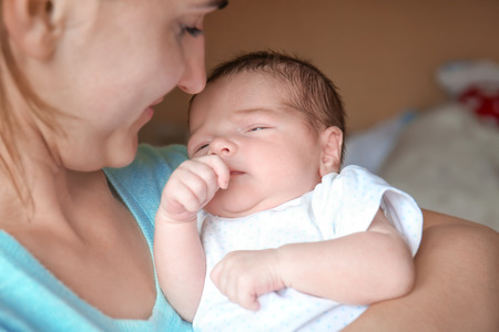 Happy young woman holding her newborn baby boy, closeupの写真素材