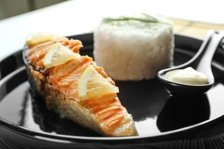 Plate with slice of salmon, rice and delicious sauce on table, closeupの写真素材