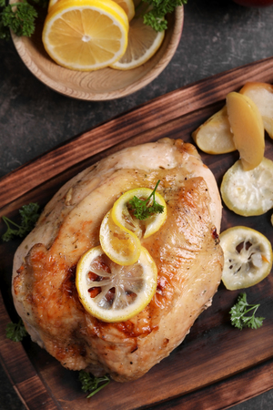 Delicious roasted turkey with sliced lemon on wooden boardの写真素材