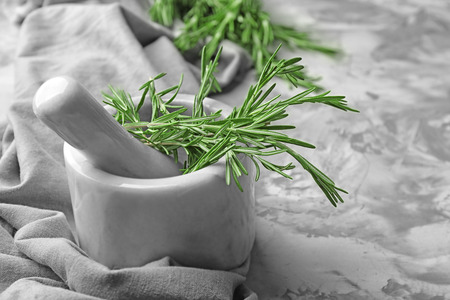 Mortar with fresh rosemary on tableの写真素材