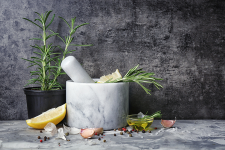 Composition with pot of rosemary and spices on tableの写真素材