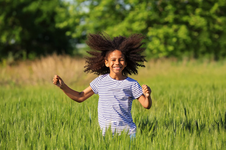 Little Afro American girl in green fieldの写真素材