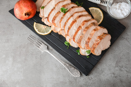 Cutting board with delicious sliced turkey fillet on tableの写真素材