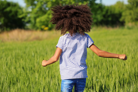 Little Afro American girl in green fieldの写真素材