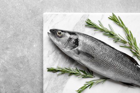 Fresh fish with rosemary on gray backgroundの写真素材