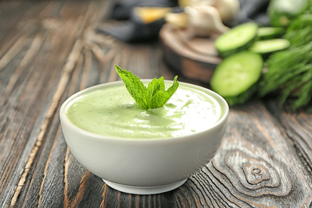 Delicious yogurt sauce in bowl on wooden backgroundの写真素材