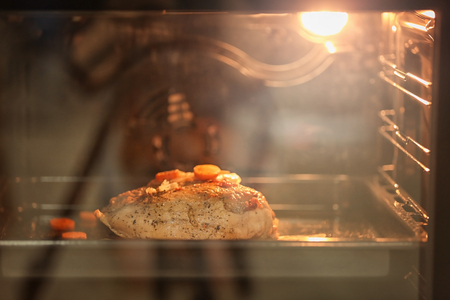 Baking tray with turkey breast cooking in ovenの写真素材