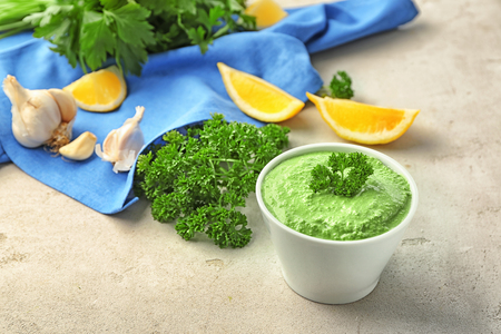 Delicious yogurt sauce in bowl with ingredients on grey backgroundの写真素材