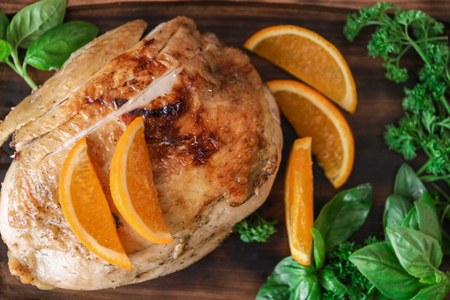 Cutting board with delicious roasted turkey and orange, closeupの写真素材