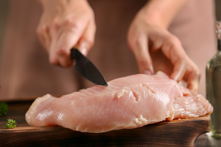 Chef cutting delicious turkey fillet on tableの写真素材