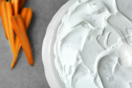 Delicious carrot cake with cream on stand, close upの写真素材