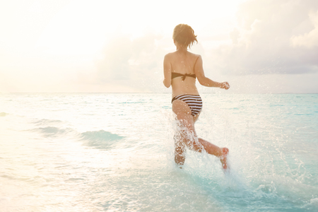 Beautiful young woman on sea beach at resortの写真素材