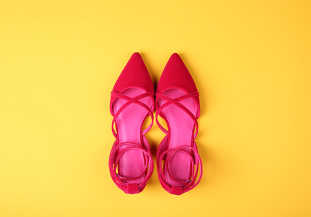 Stylish flat shoes on color background